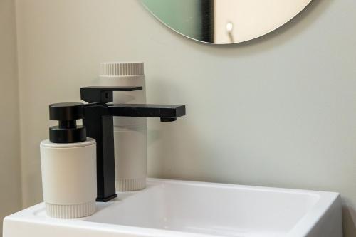 a bathroom sink with a faucet and a mirror at Alta Garden Housi João Pessoa by Carpediem in João Pessoa