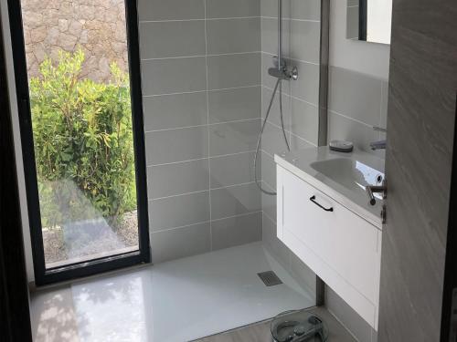 une salle de bain blanche avec un lavabo et une fenêtre dans l'établissement Villa ASTRAGALE T3, à Lecci