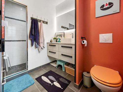 La salle de bains orange est pourvue d'une douche et de toilettes. dans l'établissement Maison de famille à 14min à pied de la mer, à Pornic