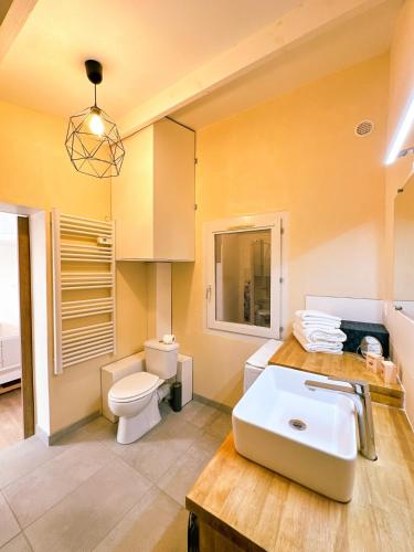 une salle de bain avec des toilettes blanches et un lavabo dans l'établissement Le Flamant Rose, à Vic-la-Gardiole