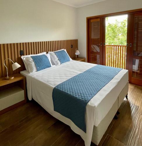 a bedroom with a large bed with blue and white sheets at Casa da Concordia in Vassouras