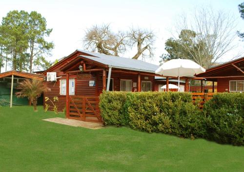 a wooden cabin with an umbrella in a yard at Cabañas Don Quirino II in Concordia