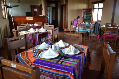 a restaurant with tables and chairs with plates and napkins on them at Hotel PrincesaToa in Quilotoa