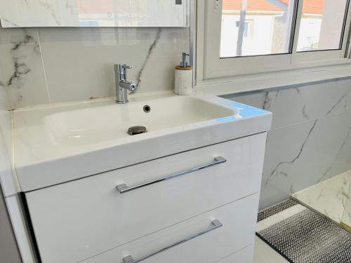 a bathroom with a white sink and a mirror at La Villa Lumière in Bourg-lès-Valence