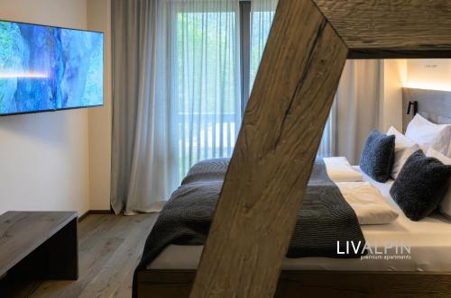 a bedroom with a wooden bed with a large window at LIVALPIN Relaxe in Garmisch-Partenkirchen
