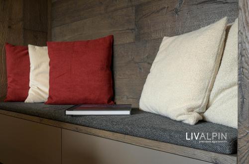 a book sitting on a bench with three pillows at LIVALPIN Relaxe in Garmisch-Partenkirchen