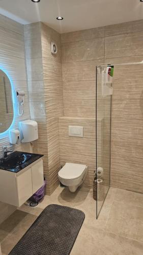 a bathroom with a toilet and a glass shower at Aparte - VG 2 in Pristina