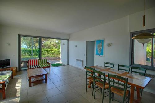 un salon avec une table et des chaises de salle à manger dans l'établissement Villa domaine de la pointe Porticcio, à Porticcio
