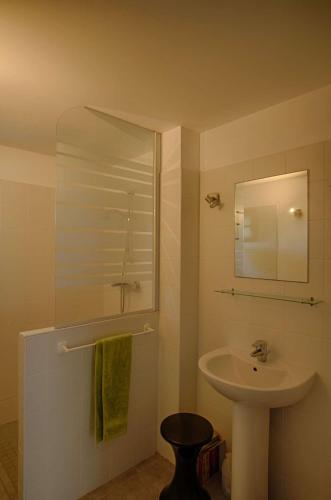 une salle de bain blanche avec un lavabo et un miroir dans l'établissement Villa domaine de la pointe Porticcio, à Porticcio