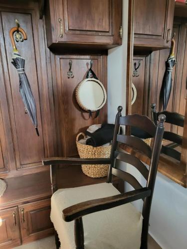 a chair in a room with wooden walls and a mirror at Bodónia Vendégház in Bodony