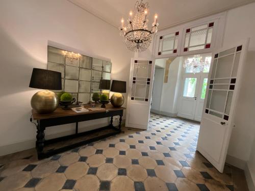 a living room with a table and a chandelier at Le Clos Notre Dame hôtel particulier hypercentre Poitiers in Poitiers