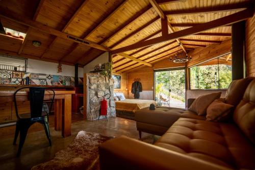 a living room with a couch and a bed at Cabana Lobo Guará in Paiol Grande