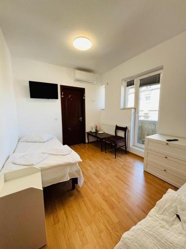 a room with two beds and a desk in it at Iancu Apartments in Bucharest