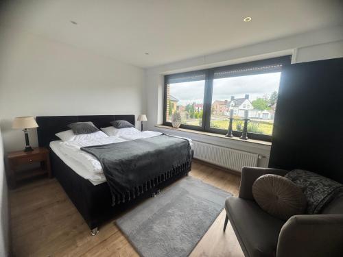 a bedroom with a bed and a couch and a window at Ferienhaus Zipfelstube in Selfkant