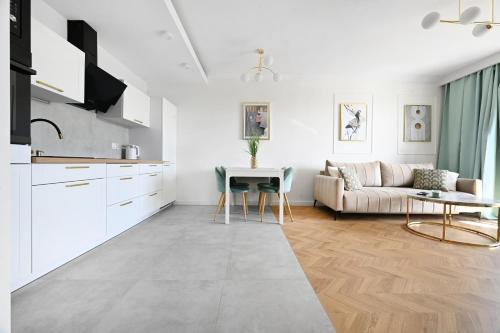 Una sala de estar blanca con un sofá y una mesa. en Apartament GOLD DELUXE, en Gdansk