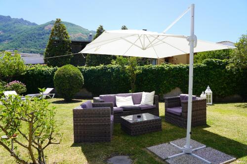 an umbrella and two couches and a table and an umbrella at Hotel Parco Delle Agavi in Ischia
