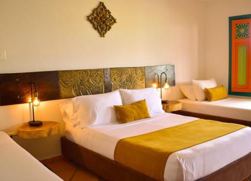 a hotel room with a large bed with two lamps at Hotel Campestre Cafe Cafe in Montenegro