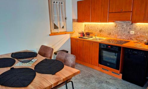 eine Küche mit einem Holztisch mit Stühlen und einem Waschbecken in der Unterkunft Appartement 14 - Résidence Conseil au coeur du village in Saint-Gervais-les-Bains