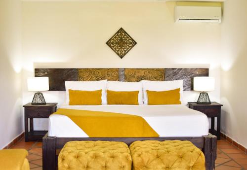 a bedroom with a large bed with two lamps at Hotel Campestre Cafe Cafe in Montenegro