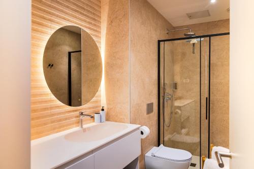 a bathroom with a sink and a toilet and a mirror at Vila Nina Bohinj in Bohinj