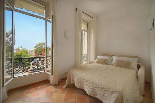 une chambre avec un lit et une grande fenêtre dans l'établissement beau 2 pieces vue mer port A1B271, à Cannes