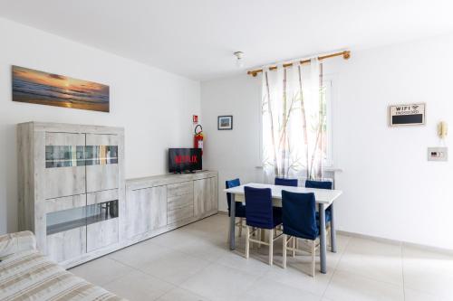 a dining room with a table and blue chairs at La Casa Del Mare Private Parking And WiFi in Lido Adriano