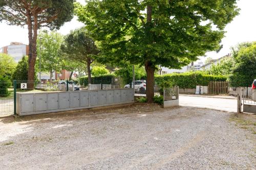 a fence next to a tree and a street at La Casa Del Mare Private Parking And WiFi in Lido Adriano