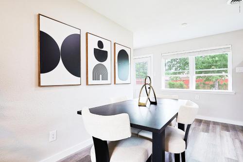 a dining room with a black table and white chairs at Luxury 4BR Retreat 10 Mins to Downtown & Lake in Mesquite