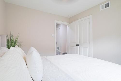 a white bedroom with a white bed with white pillows at Luxury 4BR Retreat 10 Mins to Downtown & Lake in Mesquite