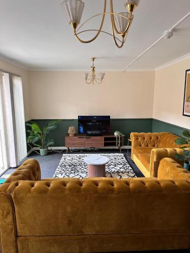 a living room with two couches and a tv at 3BR Flat Sleeps 6 West End Sights Driveway in Glasgow