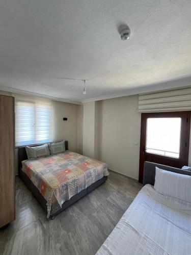 a bedroom with two beds and a window at Ayvalık Akan Pansiyon in Ayvalık
