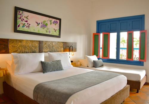 a hotel room with two beds and windows at Hotel Campestre Cafe Cafe in Montenegro