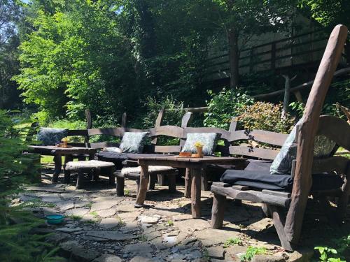 a group of wooden benches and a table and chairs at Jurta Les Park in Vřesovice