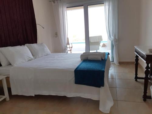 a bedroom with a white bed and a piano at Villa Oliva in Porto Heli