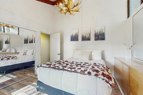 a white bedroom with a bed and a chandelier at Cielo Ridge in Twin Peaks