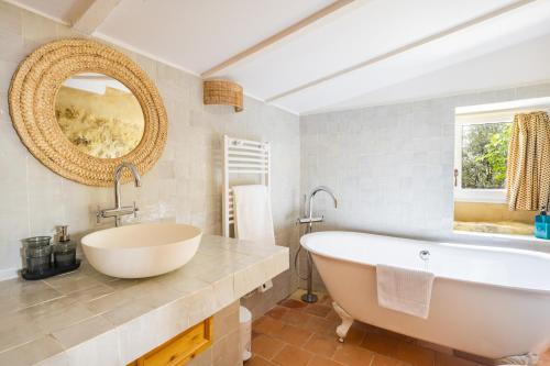 une salle de bain avec une grande baignoire et un miroir dans l'établissement Le Mazelli des Dentelles - Vue Panoramique, à Suzette