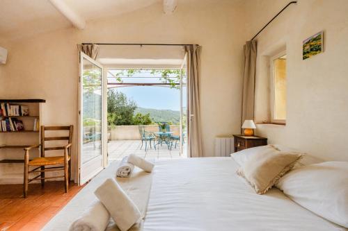 une chambre avec un grand lit et un balcon dans l'établissement Le Mazelli des Dentelles - Vue Panoramique, à Suzette