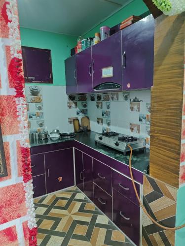 a kitchen with purple cabinets and a stove at Ma Kokila Homestay in Munsyari