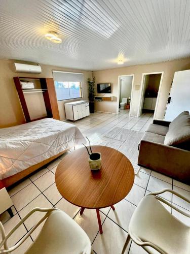 a bedroom with a bed and a table and chairs at Aconchego na Rota das Termas in Nova Prata