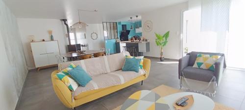 un salon avec un canapé et une chaise dans l'établissement maison au calme avec piscine proche de l'ocean, à Erdeven