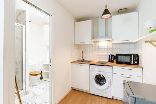 une cuisine avec un lave-linge et un micro-ondes dans l'établissement Studio au coeur du panier, à Marseille