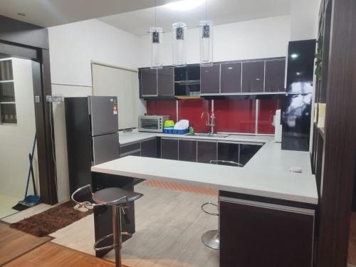 コタバルにあるOne Vista Penthouse Kota Bharuのキッチン(白いカウンター、赤いキャビネット付)