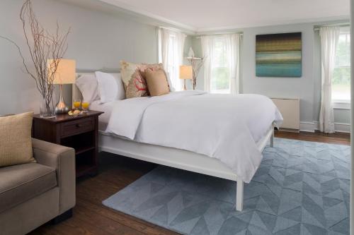 a bedroom with a large white bed and a couch at Shelter Island House in Shelter Island Heights