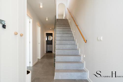 a staircase in a home with white walls and concrete floors at Luxury 3-Bed Mijas Villa, Sea View, Pool & Jacuzzi in Mijas