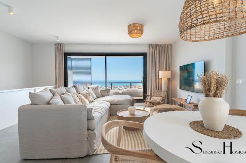 a living room with a white couch and a table at Luxury 3-Bed Mijas Villa, Sea View, Pool & Jacuzzi in Mijas