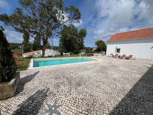 an image of a swimming pool next to a house at Quinta Pedra Firme in Sintra
