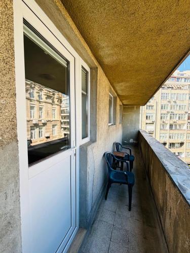 a chair sitting on a balcony with a window at Iancu Apartments in Bucharest