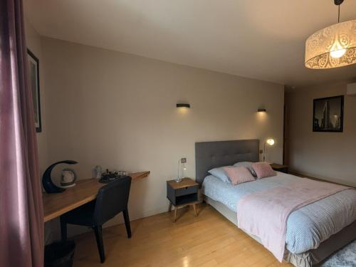 a bedroom with a bed and a desk and a desk at Au Saint-Amand in Poissons