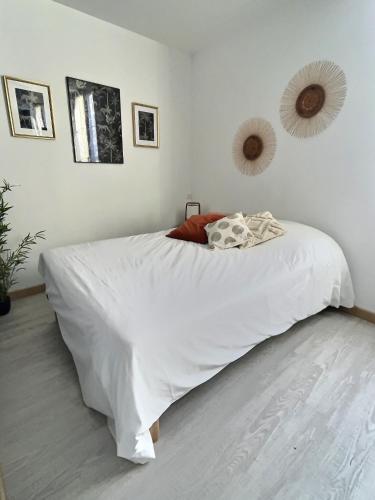 - une chambre avec un lit blanc et des draps blancs dans l'établissement Le Saint-Alpin, à Châlons-en-Champagne