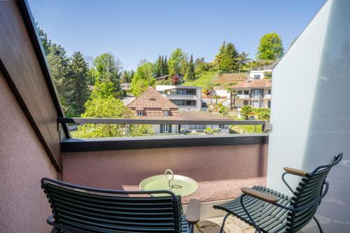 a balcony with two chairs and a table with a view at Seehotel Kastanienbaum in Luzern